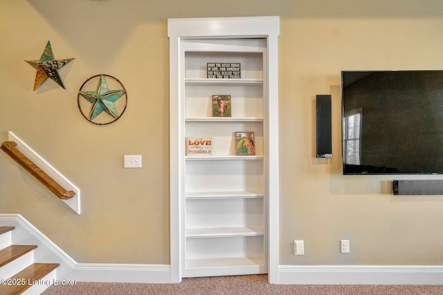 interior space with baseboards, carpet, and built in shelves