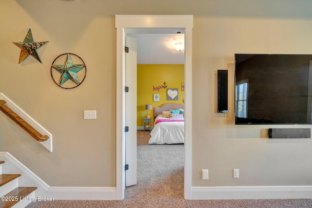 corridor with stairway, baseboards, and carpet floors