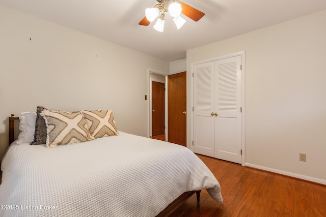 bedroom with ceiling fan, wood-type flooring, and a closet