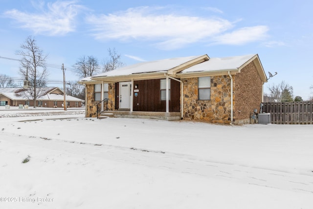 ranch-style home with stone siding and fence