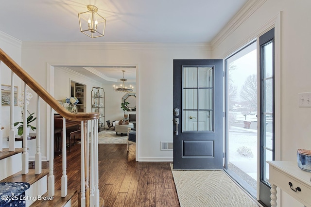 entrance foyer featuring crown molding, dark hardwood / wood-style flooring, and a chandelier