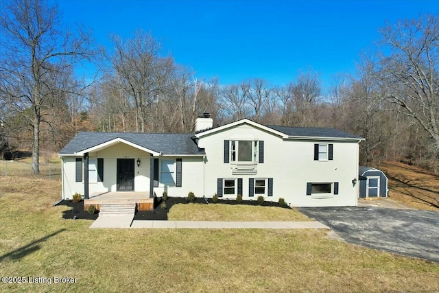 view of front of house with a front yard and a storage unit