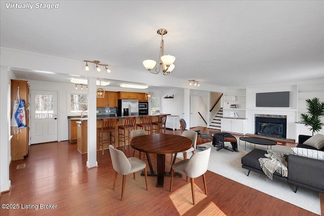 dining room featuring an inviting chandelier, dark hardwood / wood-style floors, and built in features