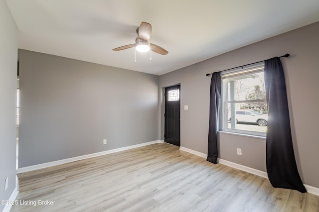 spare room with light wood-style floors, baseboards, and ceiling fan