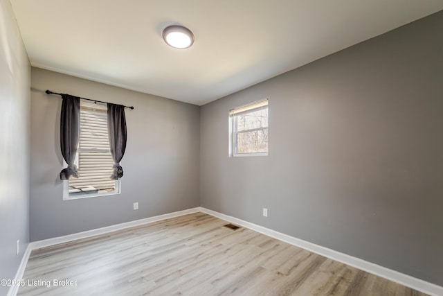 empty room with baseboards and light wood-style floors