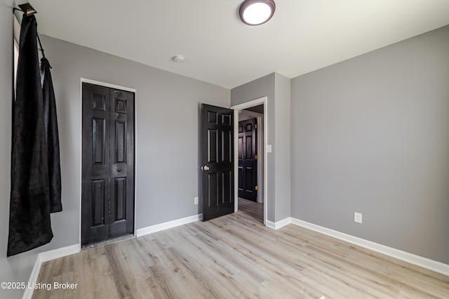 unfurnished bedroom featuring baseboards and light wood finished floors