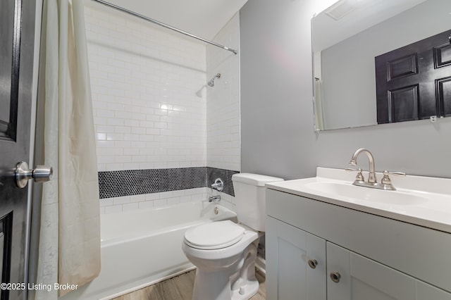 bathroom featuring vanity, toilet, wood finished floors, and shower / bath combo