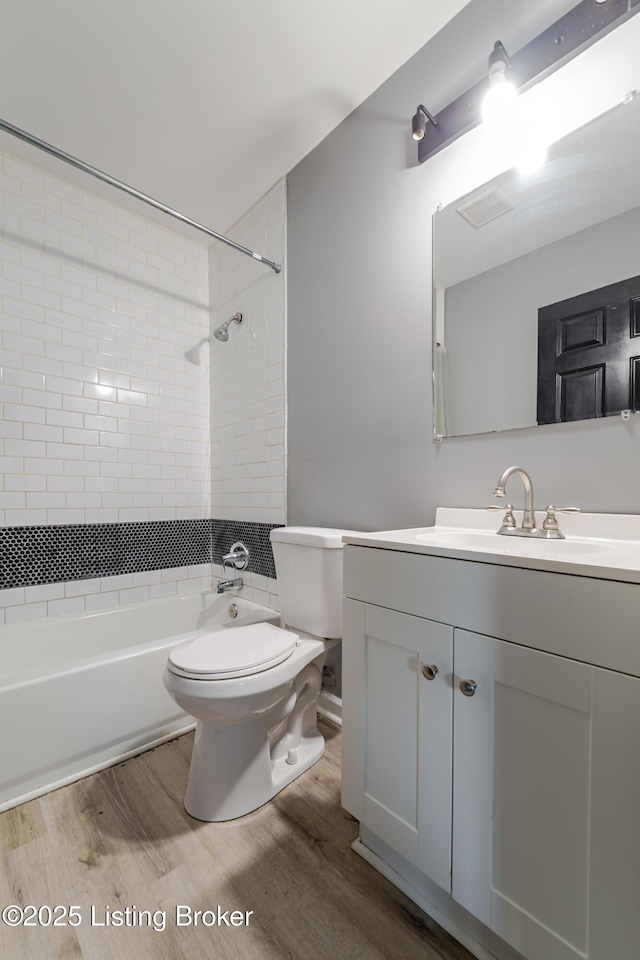 bathroom with vanity, toilet, shower / bathing tub combination, and wood finished floors