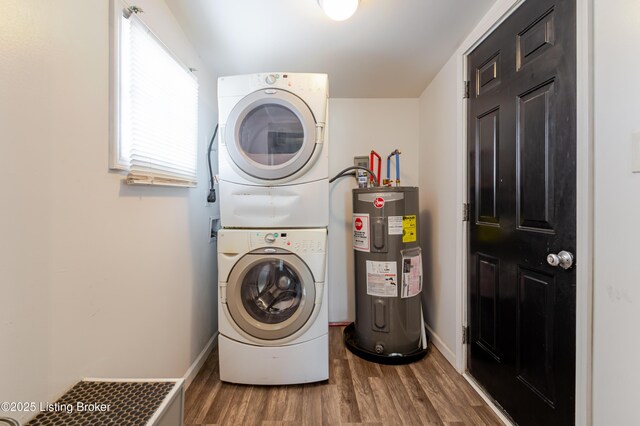 washroom featuring electric water heater, baseboards, laundry area, stacked washing maching and dryer, and wood finished floors