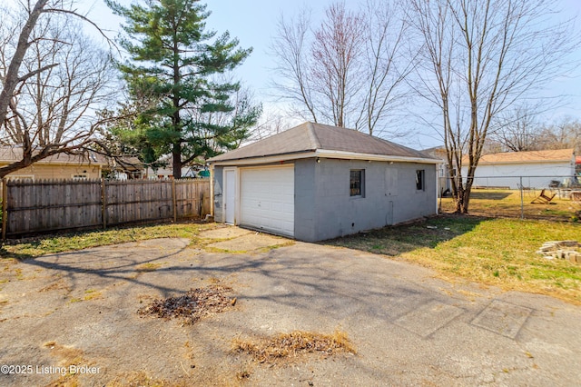 detached garage with driveway and fence