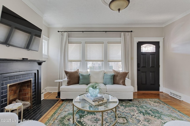 living room featuring dark hardwood / wood-style flooring, a fireplace, ornamental molding, and a textured ceiling