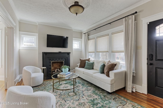 living room featuring hardwood / wood-style flooring, ornamental molding, and a textured ceiling