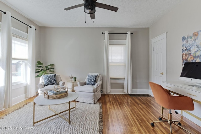 office space featuring wood-type flooring, ceiling fan, and a textured ceiling