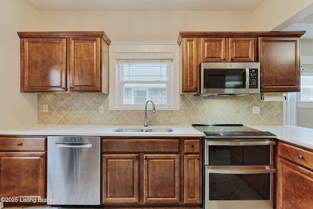 kitchen with a healthy amount of sunlight, appliances with stainless steel finishes, sink, and backsplash