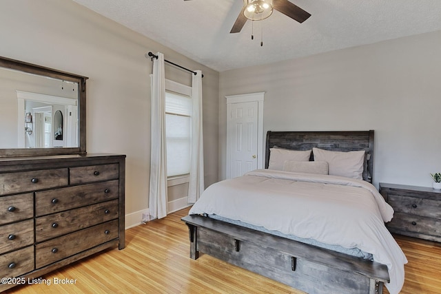 bedroom featuring ceiling fan, a textured ceiling, and light wood-type flooring