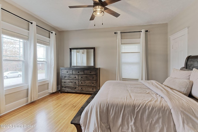 bedroom featuring ceiling fan, a textured ceiling, and light wood-type flooring