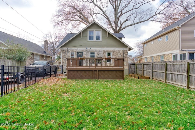 back of property featuring a wooden deck and a yard