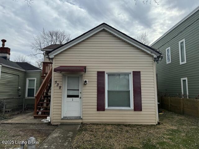 view of front of home with stairs and fence