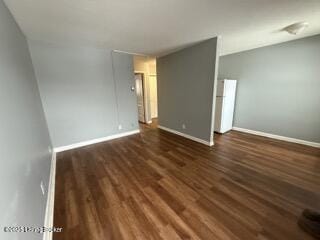 unfurnished room with dark wood-type flooring