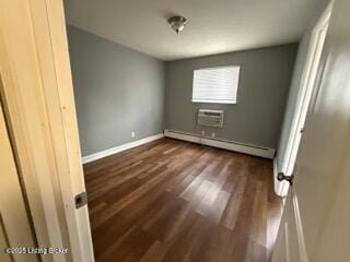 unfurnished bedroom with a baseboard heating unit, a wall mounted AC, and dark hardwood / wood-style floors