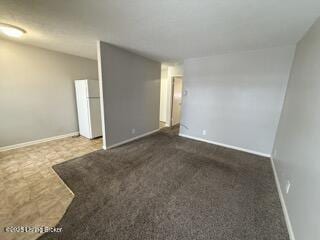 empty room featuring lofted ceiling and dark carpet