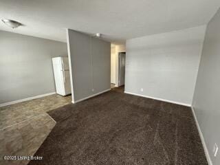 unfurnished room featuring dark carpet