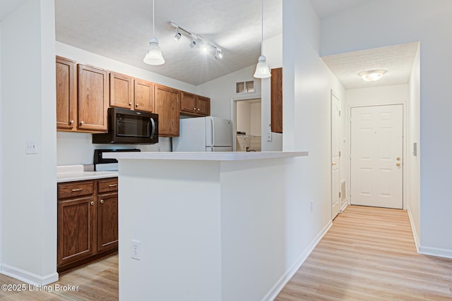 kitchen featuring baseboards, visible vents, light wood-style flooring, freestanding refrigerator, and a textured ceiling