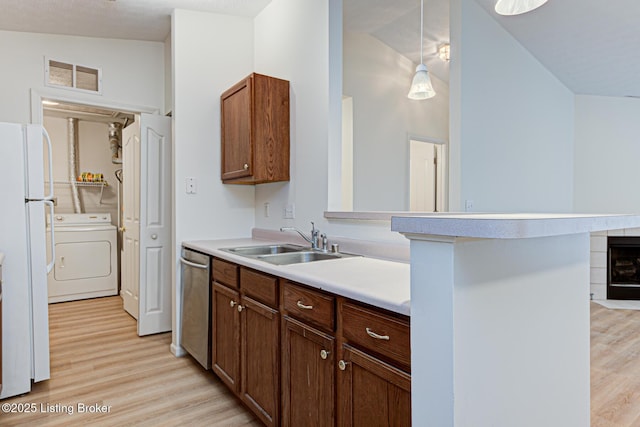 kitchen featuring visible vents, dishwasher, washer / clothes dryer, freestanding refrigerator, and a sink