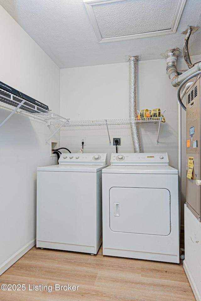 laundry room with laundry area, attic access, separate washer and dryer, and light wood-style floors