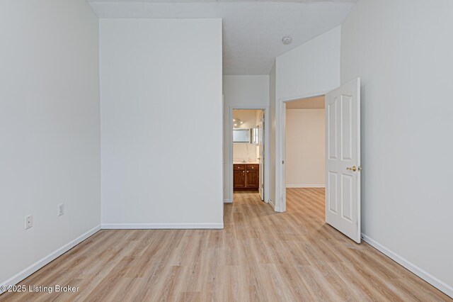 unfurnished room featuring light wood-type flooring and baseboards