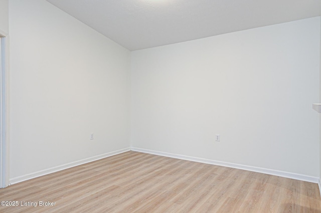 spare room with light wood finished floors and baseboards