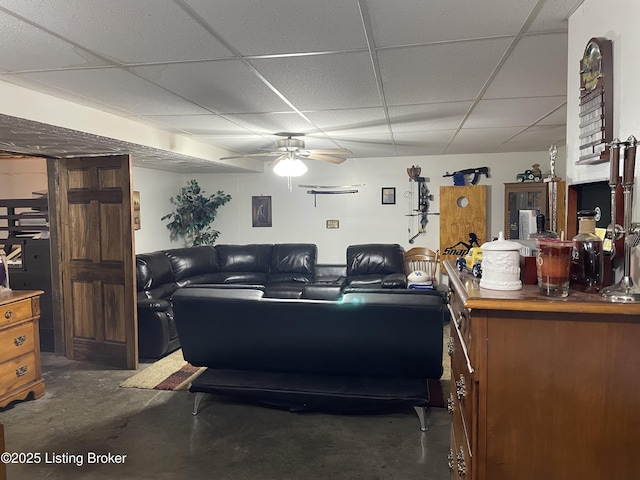 living room with ceiling fan and a drop ceiling