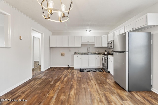 kitchen featuring sink, white cabinetry, stainless steel appliances, dark hardwood / wood-style floors, and decorative light fixtures