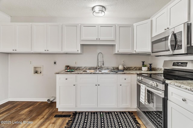 kitchen featuring dark hardwood / wood-style floors, white cabinetry, sink, light stone counters, and stainless steel appliances