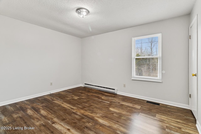 empty room featuring dark hardwood / wood-style flooring, a baseboard radiator, and a textured ceiling