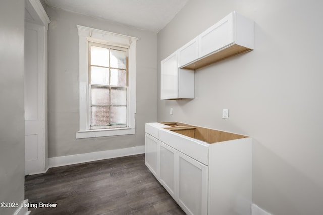 bar with white cabinetry and dark hardwood / wood-style flooring