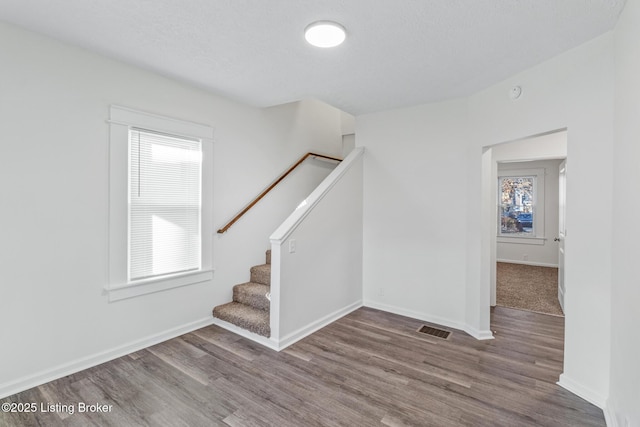 4145 W Muhammad Ali Blvd, Louisville, KY 40212 - staircase featuring hardwood / wood-style flooring and a textured ceiling