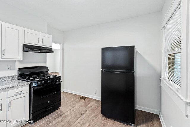 4145 W Muhammad Ali Blvd, Louisville, KY 40212 - kitchen featuring white cabinetry, light stone countertops, light hardwood / wood-style floors, and black appliances