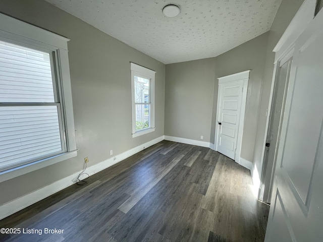 unfurnished room featuring dark hardwood / wood-style floors and a textured ceiling