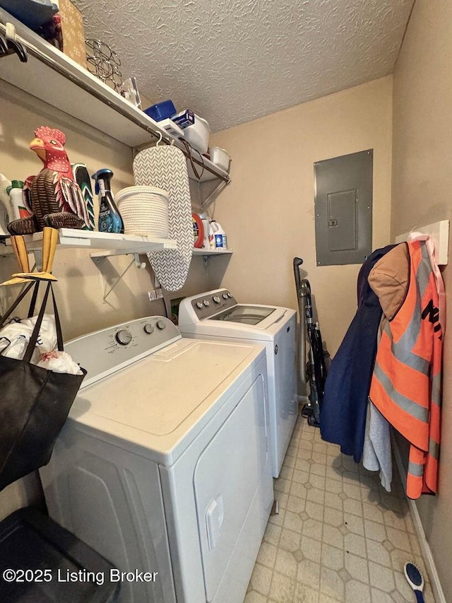 clothes washing area with electric panel, washer and clothes dryer, and a textured ceiling