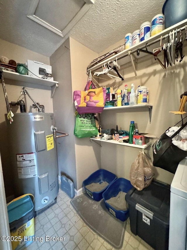 washroom featuring washer / clothes dryer, electric water heater, and a textured ceiling