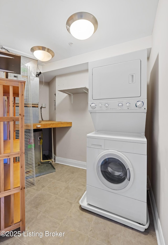 laundry room with laundry area, baseboards, and stacked washing maching and dryer