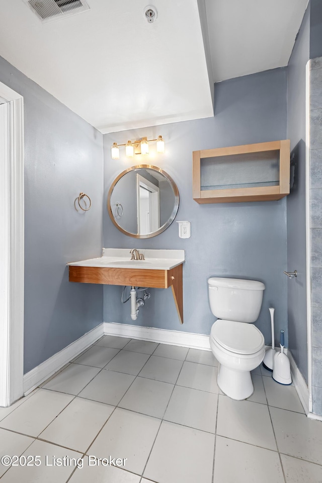 half bath featuring tile patterned floors, visible vents, baseboards, and toilet