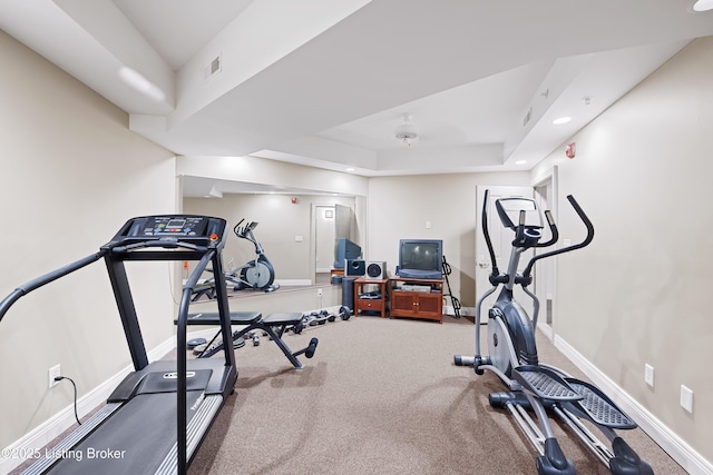 workout area with visible vents, recessed lighting, a raised ceiling, and baseboards