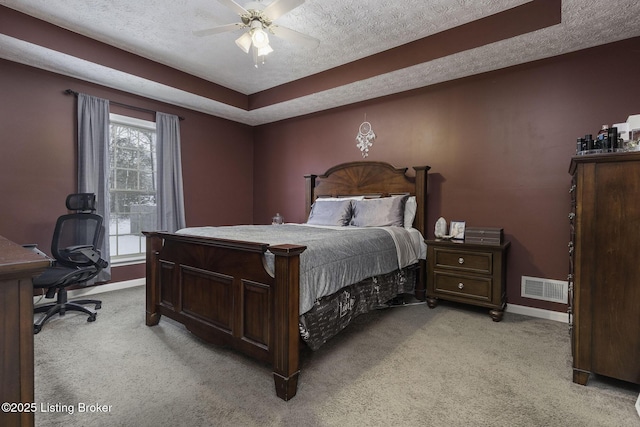 bedroom with baseboards, visible vents, a textured ceiling, and light colored carpet