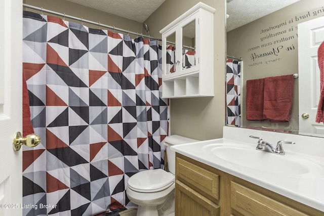 bathroom with toilet, a textured ceiling, and vanity