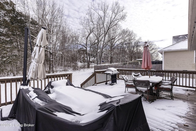 snow covered deck featuring outdoor dining area and a grill