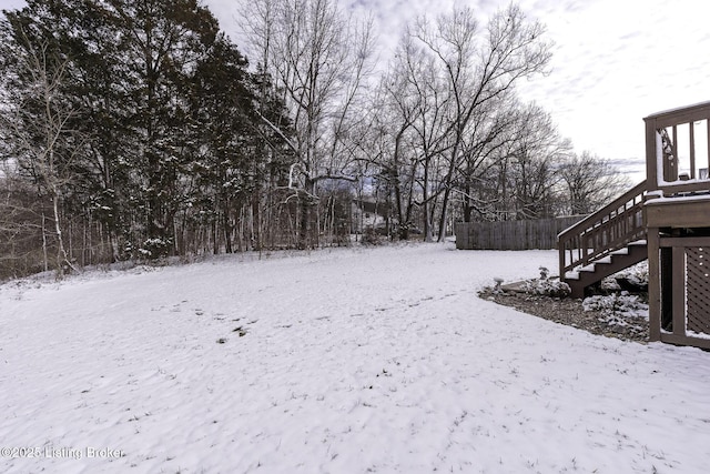 yard covered in snow featuring stairs