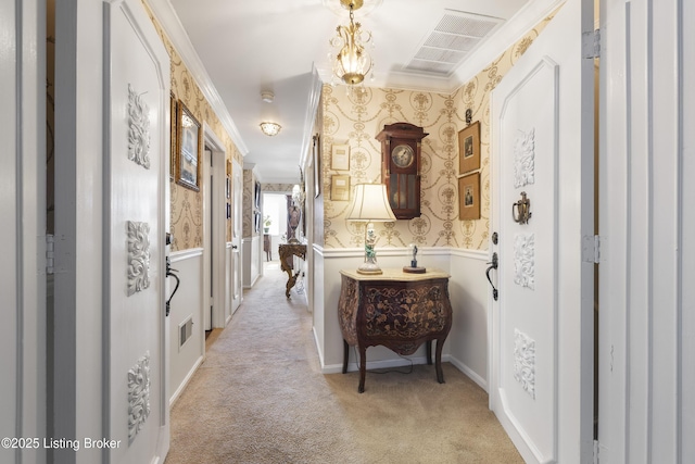 hall with ornamental molding and light carpet