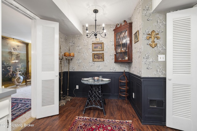 bar featuring dark hardwood / wood-style flooring, hanging light fixtures, and an inviting chandelier